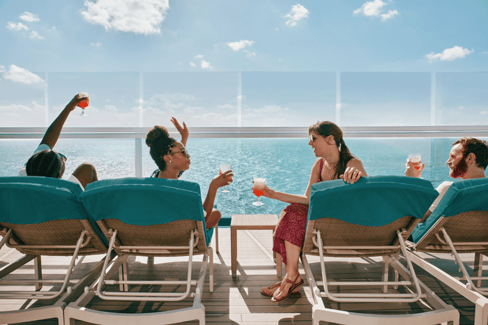 Cruisers lounging on chairs on the lido deck